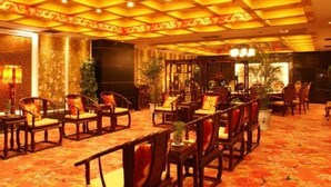 A traditional-style room with wooden furniture and a patterned carpet. - Sijiwenhua Hotel (Feicheng)