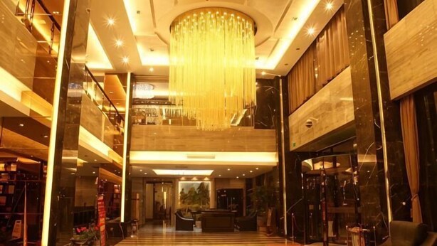 A spacious lobby with a grand chandelier, multiple floors, and a modern design. - Sijiwenhua Hotel (Feicheng)