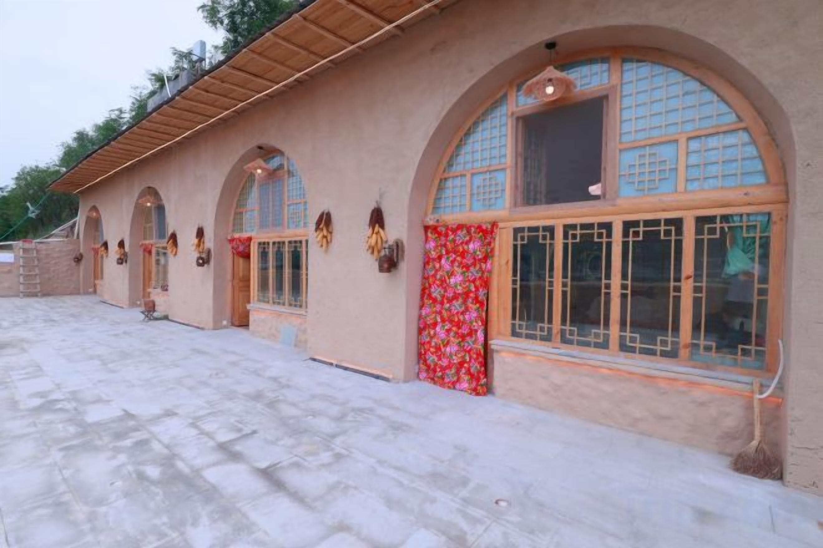 A building with arched windows and a tiled walkway.