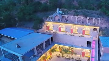 Un hôtel doté d’une cour intérieure, de nombreuses arcades et d’un espace extérieur aménagé avec des sièges, protégé par un toit.