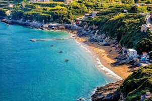 Una zona costera con playa, barcos y edificios.