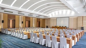A conference room with rows of tables and chairs, a large screen, and a podium. - Yunlong Hotel (Wenling Yintai Branch) (Wenling)