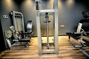 A gym with exercise equipment including a squat rack, a bench, and a treadmill. - Yunlong Hotel (Wenling Yintai Branch) (Wenling)