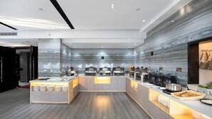 A modern kitchen area with a marble backsplash, a central island with seating, and various kitchen appliances. - Yunlong Hotel (Wenling Yintai Branch) (Wenling)
