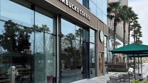 A Starbucks Coffee storefront with large glass windows and outdoor seating. - Yunlong Hotel (Wenling Yintai Branch) (Wenling)