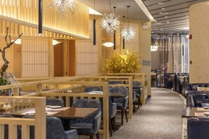 A restaurant interior with wooden furniture, hanging lights, and a carpeted floor. - Yunlong Hotel (Wenling Yintai Branch) (Wenling)