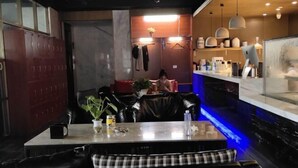 A restaurant with a bar area, seating with checkered cushions, and a counter with various items. - Yunlong Hotel (Wenling Yintai Branch) (Wenling)
