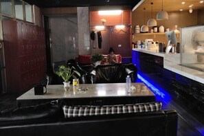 A restaurant with a bar area, seating with checkered cushions, and a counter with various items. - Yunlong Hotel (Wenling Yintai Branch) (Wenling)