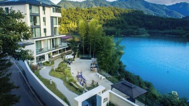 A modern hotel with a pool, surrounded by lush greenery and mountains. - Hi Ta B&B (Chun'an)