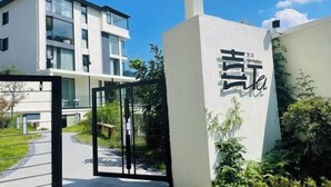 A modern building with a large glass facade and a white exterior. - Hi Ta B&B (Chun'an)