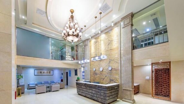 Un'ampia hall con reception, area salotto e un lampadario.