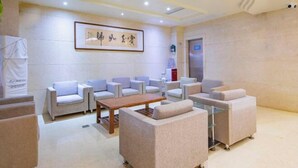 Una hall con posti a sedere, una reception e un quadro appeso al muro.