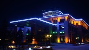 A hotel with a modern design, featuring a prominent entrance and illuminated signage. - Mohe International Conference Center (Mohe)