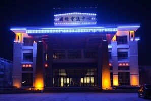Un edificio con una entrada amplia y señalización iluminada.
