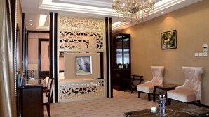 A hotel lobby with a chandelier, seating area, and a decorative partition. - Mohe International Conference Center (Mohe)