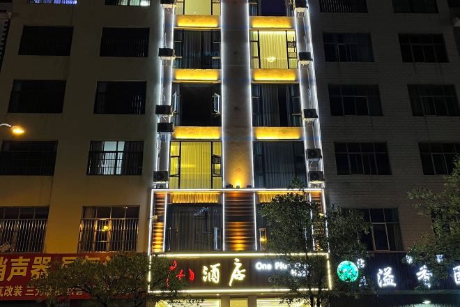 A multi-story building with illuminated signage and windows.