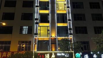 A multi-story building with illuminated signage and windows.