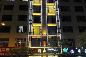 Un edificio de varios pisos con señalización iluminada y ventanas.