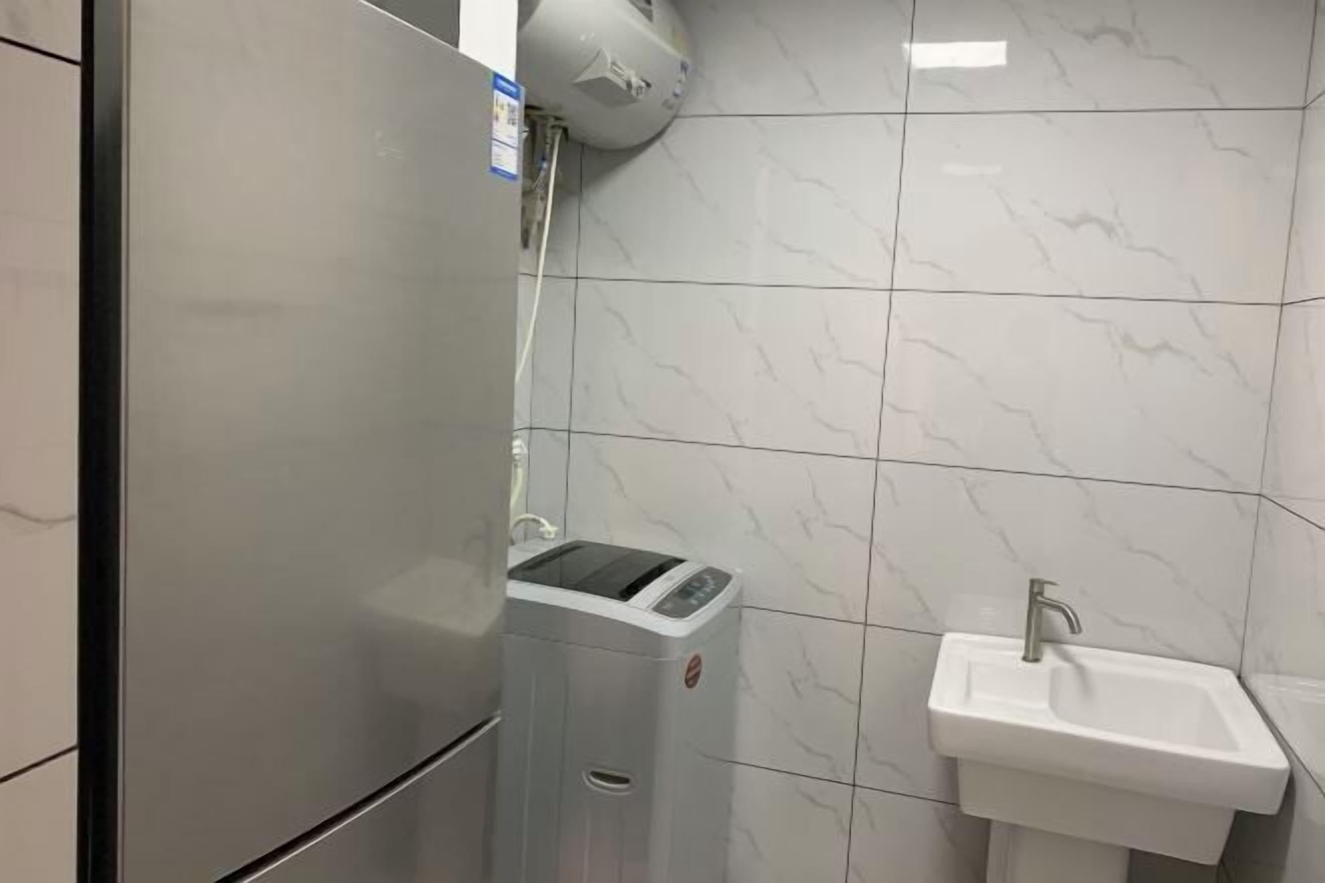 A bathroom with a white sink, a mirror, and a hand dryer.