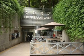 A library entrance with a sign, outdoor seating, and a wooden deck. - Qingmu Hotel (Nanjing Wutaishan Guangzhou Road Suiyuan Building) (Nanjing)