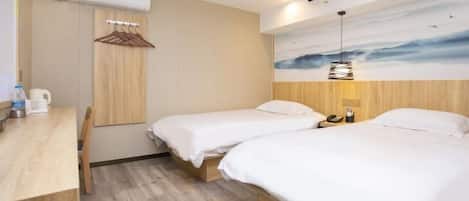 Habitación de hotel con dos camas, un escritorio de madera, aire acondicionado de pared y un cuadro de un cielo nublado.