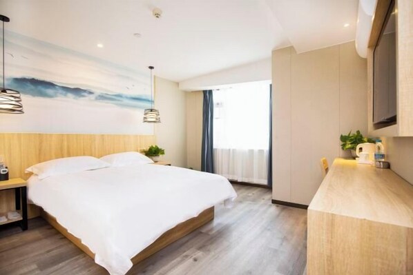 A modern hotel room with a wooden bed, a desk with a plant, and a large window. - Qingmu Hotel (Nanjing Wutaishan Guangzhou Road Suiyuan Building) (Nanjing)