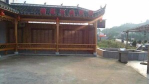 Un bâtiment traditionnel chinois, doté d’un toit recouvert de tuiles et de poutres en bois.