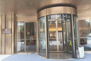 A revolving door entrance with glass panels and a sign above it. - Landmark International Hotel(East Railway Station Tianhe Sport Center Branch) (Guangzhou)