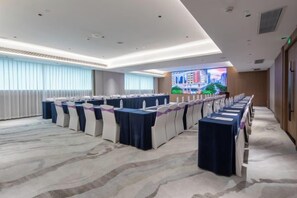 A conference room with multiple tables, a large screen, and a cityscape view. - Landmark International Hotel(East Railway Station Tianhe Sport Center Branch) (Guangzhou)