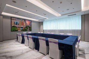 A conference room with a long table, chairs, and a large screen. - Landmark International Hotel(East Railway Station Tianhe Sport Center Branch) (Guangzhou)