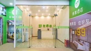 A hotel reception area with glass doors, a reception desk, and a green wall with text. - Haoyou (Shanghai Songjiang Qiujing Road) (Shanghai)