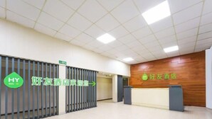 A hotel reception area with a wooden wall, a reception desk, and a sign indicating the direction to the lobby. - Haoyou (Shanghai Songjiang Qiujing Road) (Shanghai)