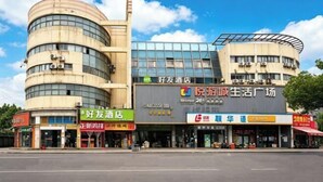 A multi-story building with a curved facade, a large glass window, and signage for a hotel and a market. - Haoyou (Shanghai Songjiang Qiujing Road) (Shanghai)