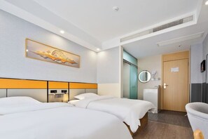 Une chambre d’hôtel avec deux lits, une salle de bain, une douche et des toilettes.