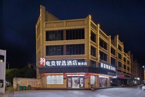 Een meerhoog gebouw met verlichte reclameborden en een winkelpui op de begane grond.