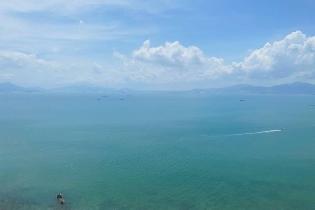 A coastal view with a clear sky and distant mountains.