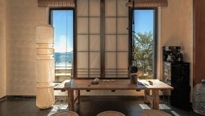 A traditional Japanese room with tatami flooring, a low table, a shoji screen, and a large window. - Huidong Sumao Homestay (Xunliao Bay) (Huidong)