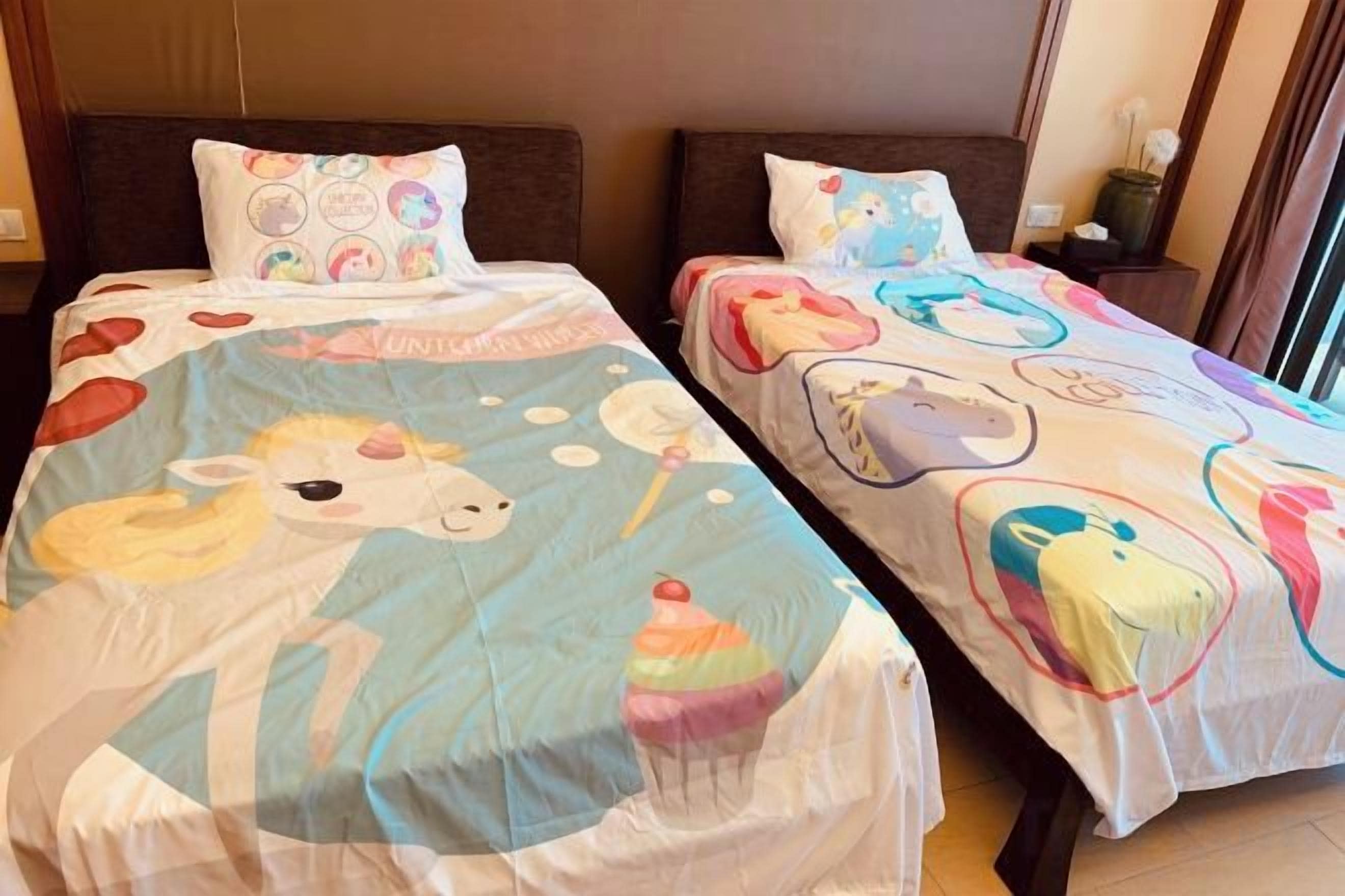 Two twin beds with matching headboards and nightstands, each with a patterned bedspread and pillows.