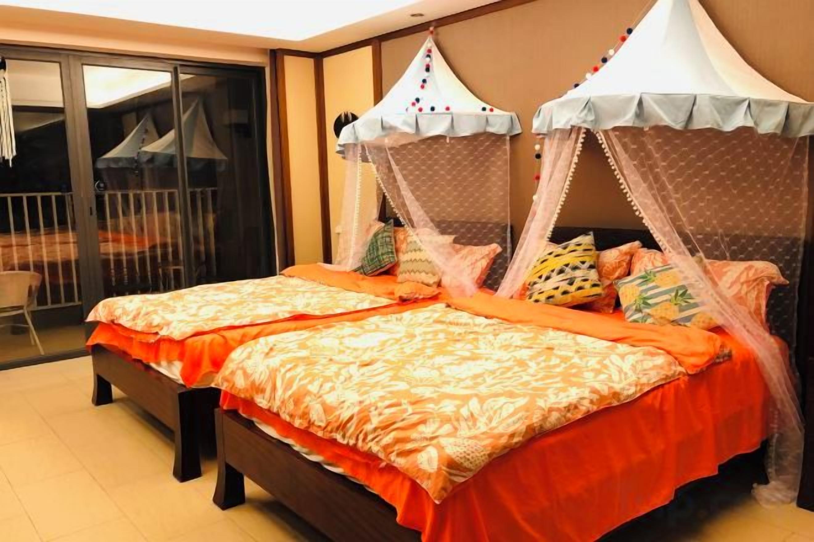 A double bed with a canopy, a sliding glass door, and a view of the outside.