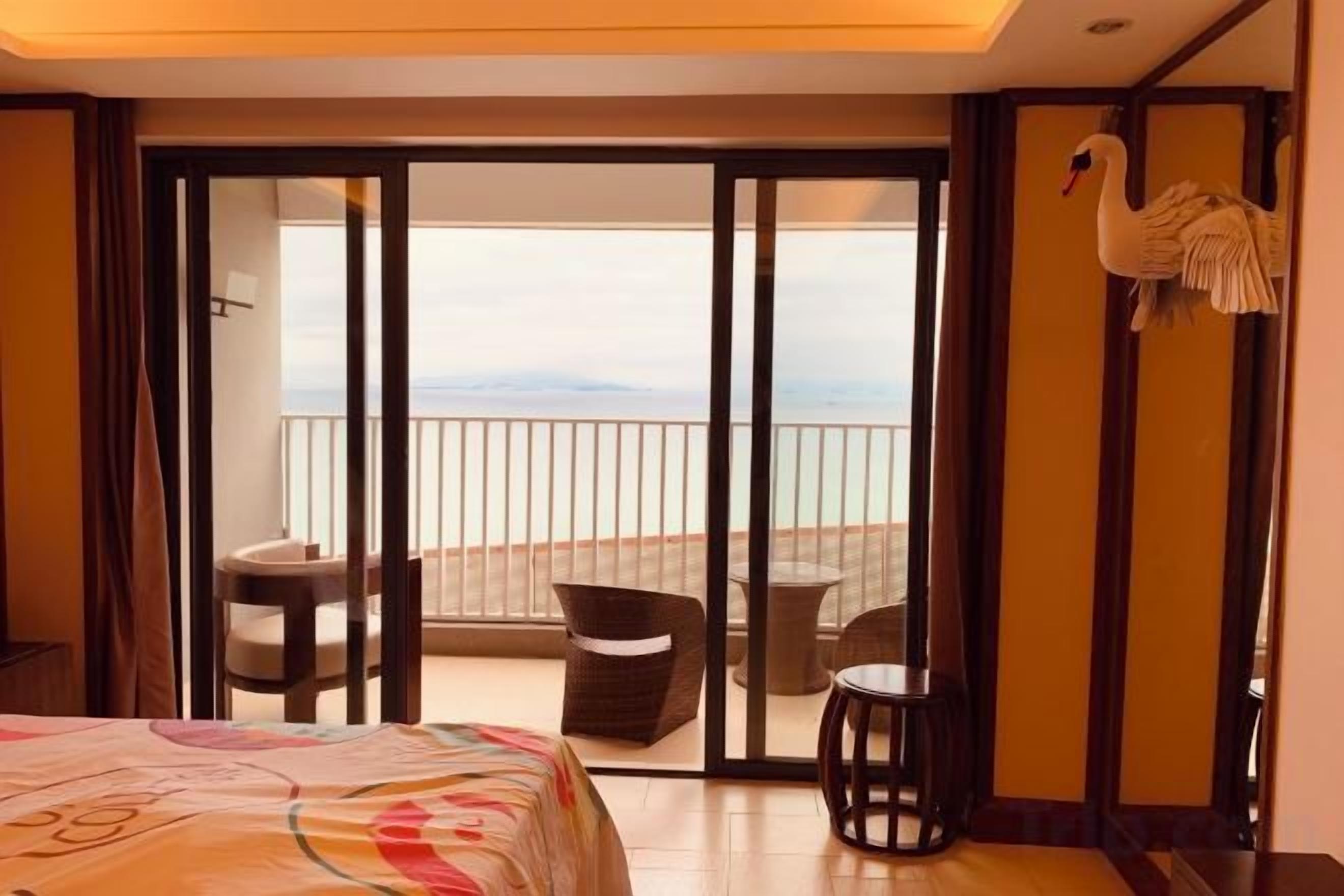 Quarto de hotel com cama, varanda e decoração com cisne.