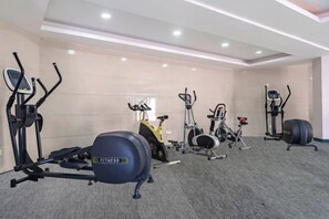 A gym with stationary bikes, elliptical machines, and a rowing machine. - Shenzhen Airport Hotel（Shenzhen Bao'an International Airport T3 Terminal Store） (Shenzhen)