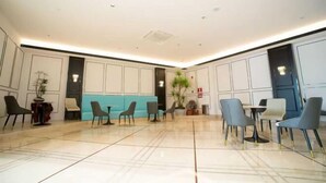 A spacious lobby with a blue accent wall, several seating areas, and a large plant. - Shenzhen Airport Hotel(Shenzhen Bao'an International Airport T3 Terminal Store) (Shenzhen)