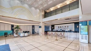A spacious lobby with a reception desk, seating area, and a digital information kiosk. - Shenzhen Airport Hotel(Shenzhen Bao'an International Airport T3 Terminal Store) (Shenzhen)
