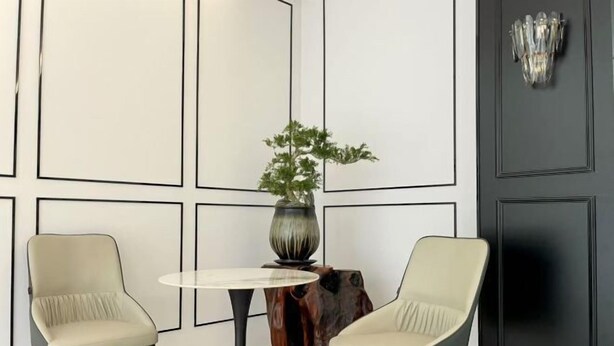 A room with two chairs, a round table, a potted plant, and a decorative wall piece. - Shenzhen Airport Hotel(Shenzhen Bao'an International Airport T3 Terminal Store) (Shenzhen)