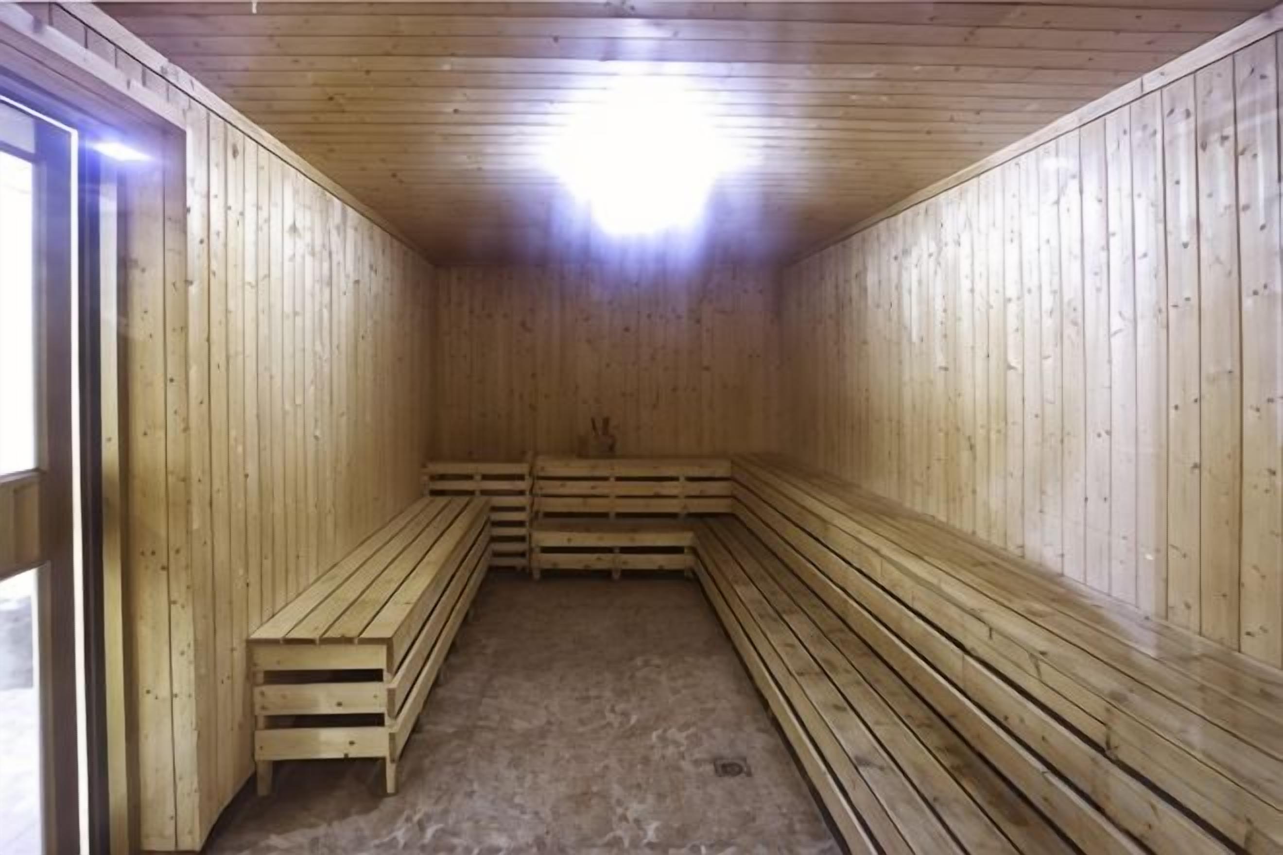 A sauna with wooden benches and a sloped ceiling.