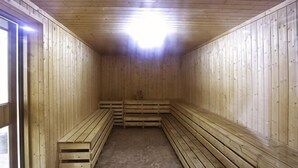 A sauna with wooden benches and a sloped ceiling. - Longdu Business Hotel (Zhaoyuan)