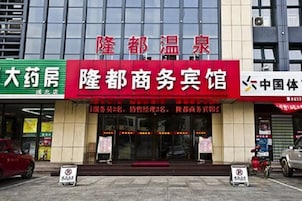 Un edificio comercial con un letrero rojo para 'Lun Dong Business Center' y un letrero verde para 'Da You House'.