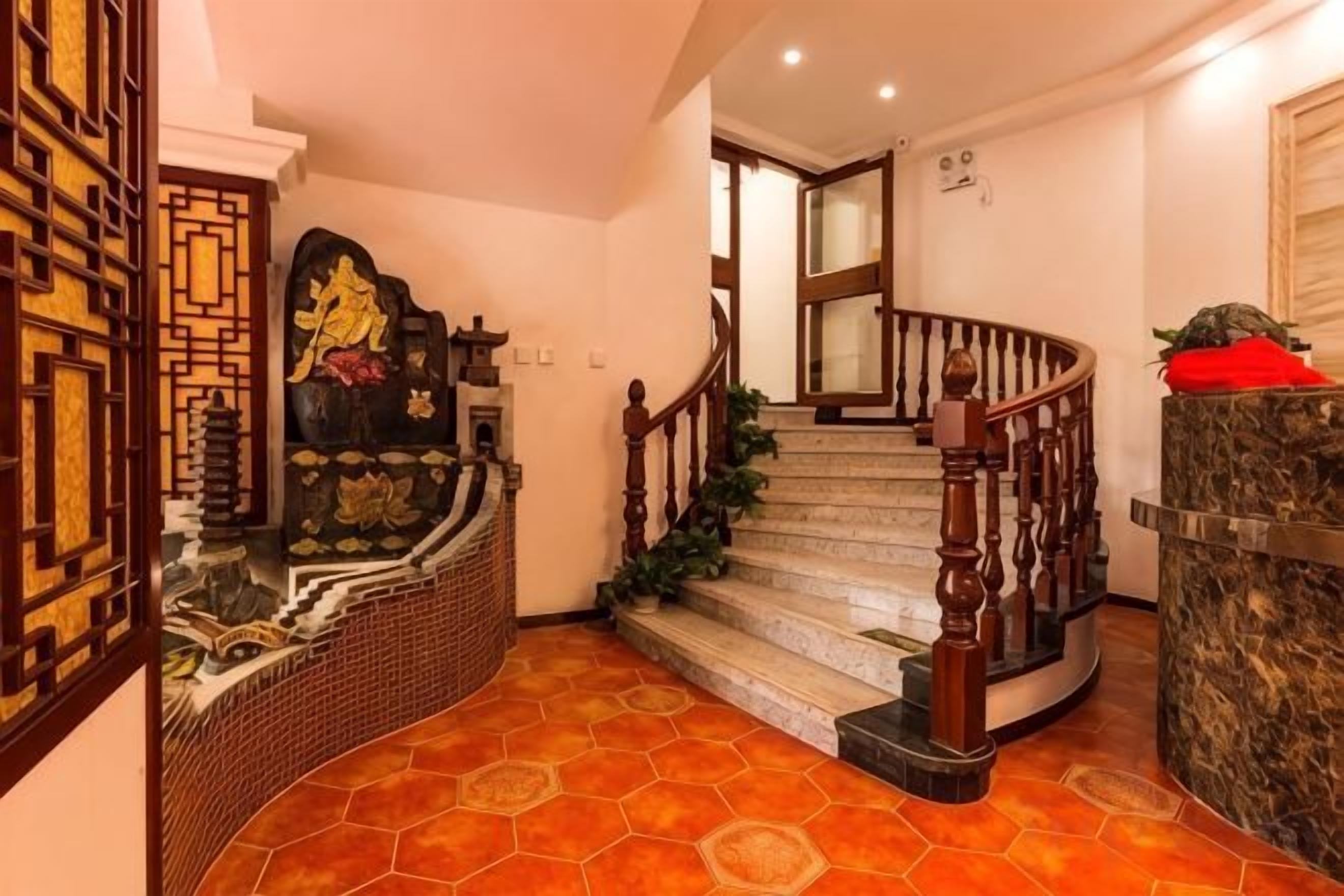 Una escalera con barandilla de madera y un cojín rojo en la parte superior.