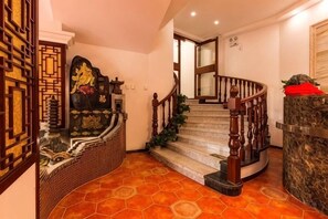 A staircase with a wooden handrail and a red cushion at the top. - Xingyu Hotel (Beijing Daxing Caiyu Branch) (Beijing)