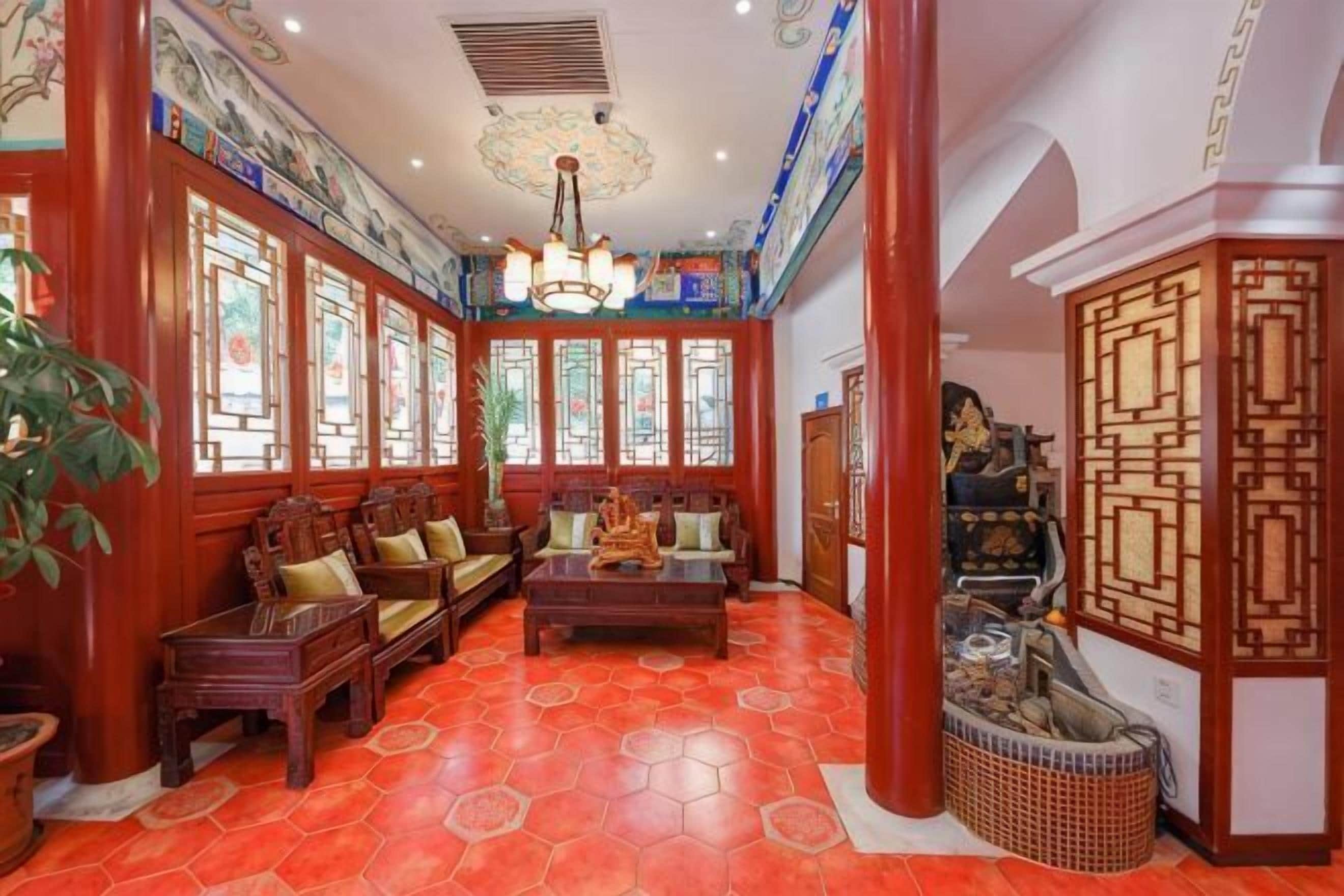 A traditional interior with wooden furniture, a patterned floor, and a decorative ceiling.